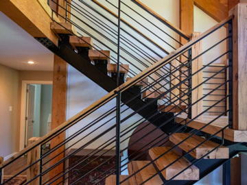 side view of wooden floating stairs with a black metal stair railing