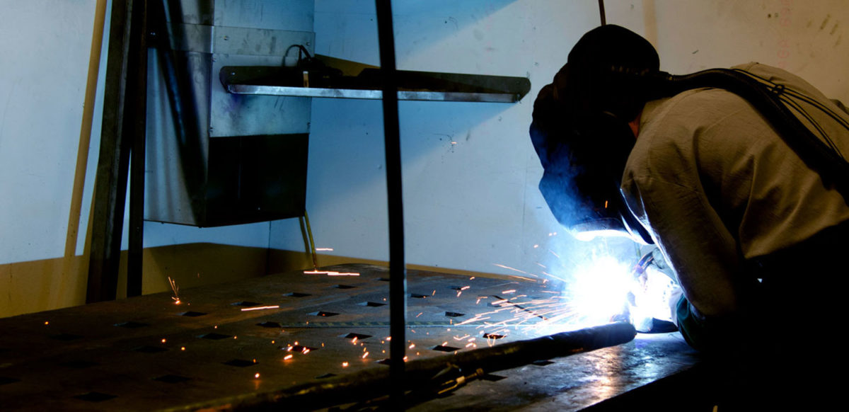 welder in the shop welding a piece of metal