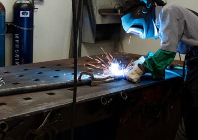 An employee welding metal with precision