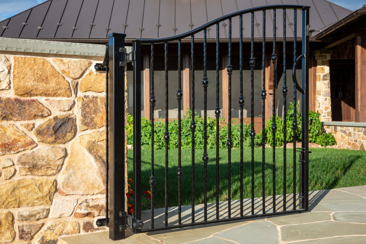 custom made black steel gate sitting in front of metal seam room