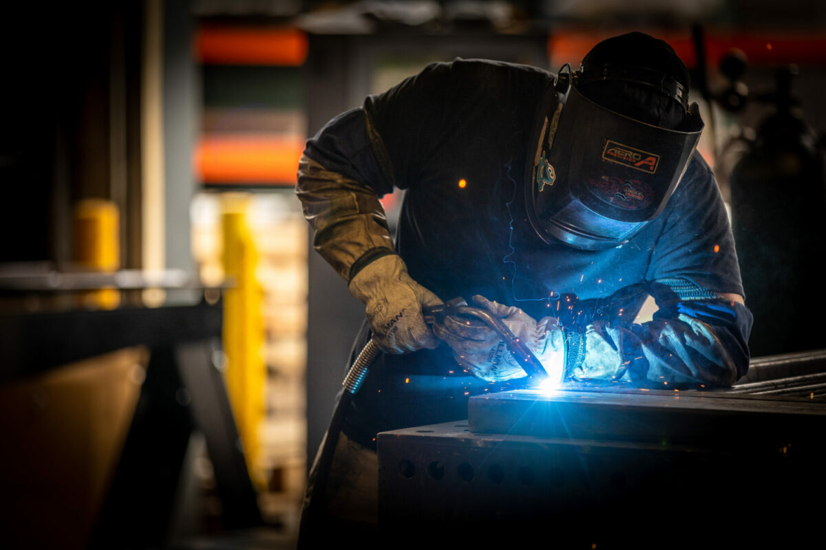 welder welding a piece of metal in the shop