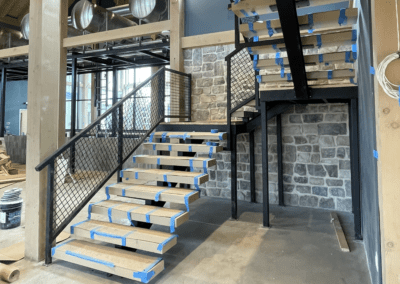 wooden stairs with metal railing under construction